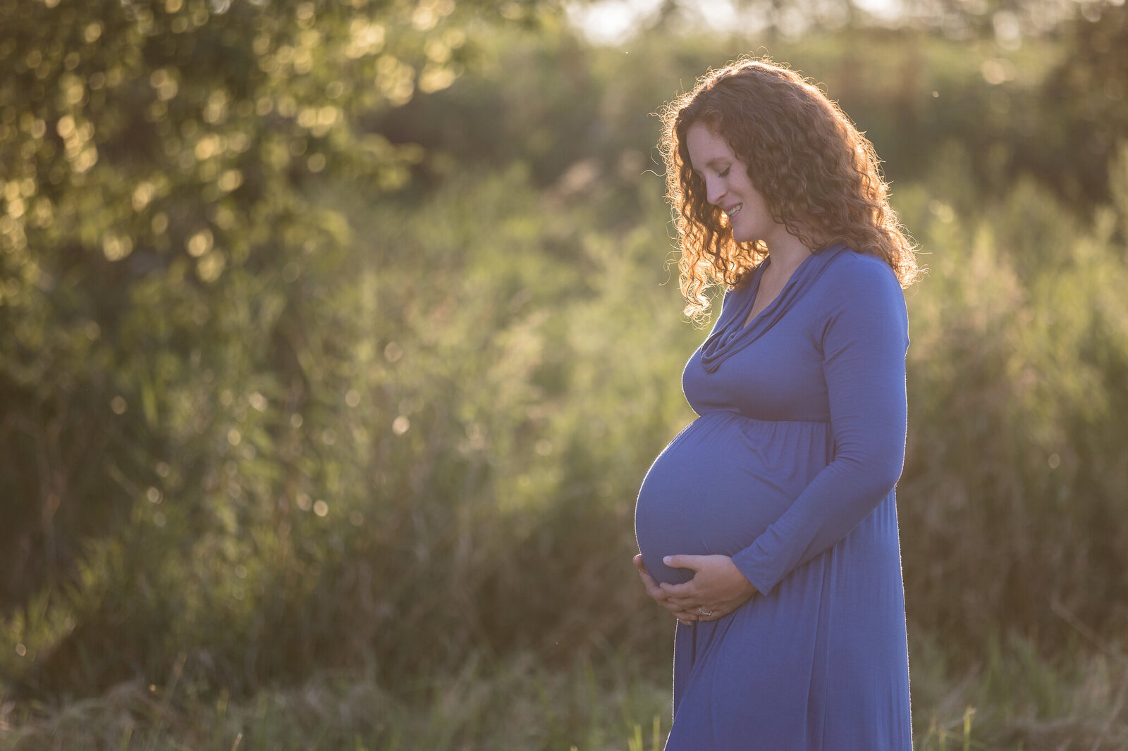 Pregnant woman in field holding belly near Tottenham Ontario