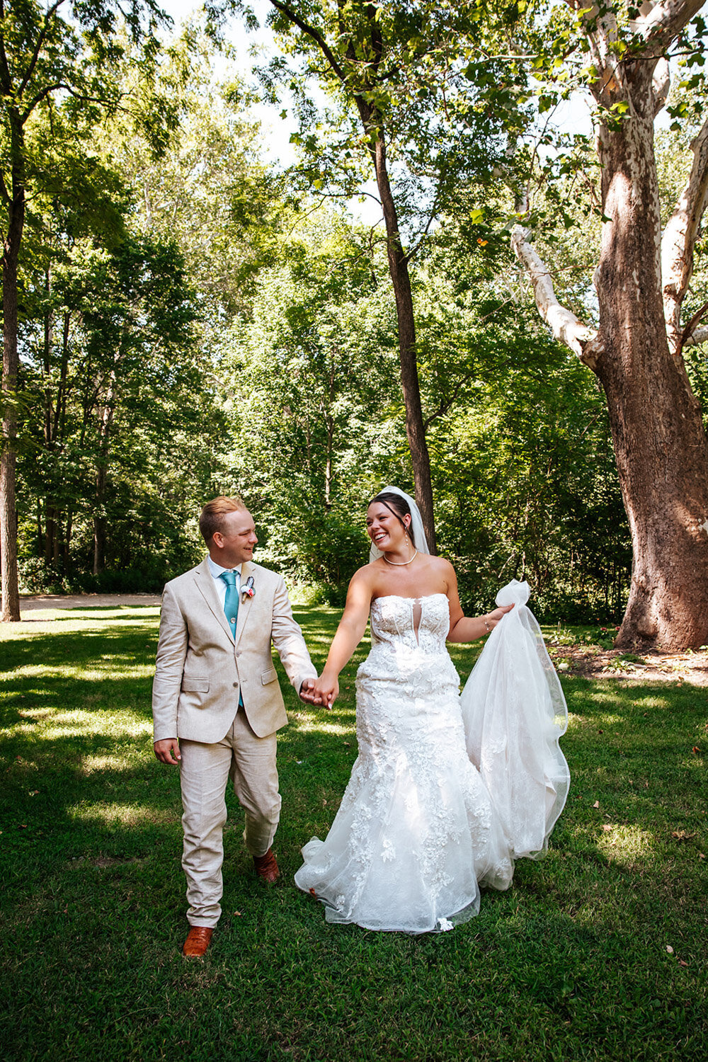Bride and groom walking while smiling at each other