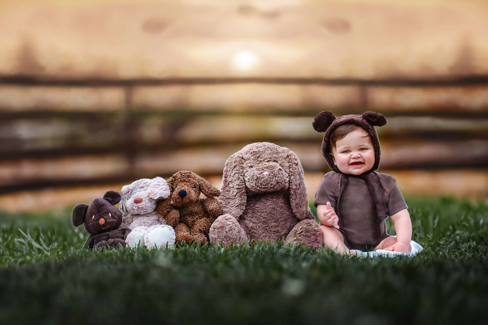 Sweet baby boy wearing a bear bonnet sitting next to his teddies in Lake Jackson, TX. Photographed by Houston family photographer Danielle Dott.