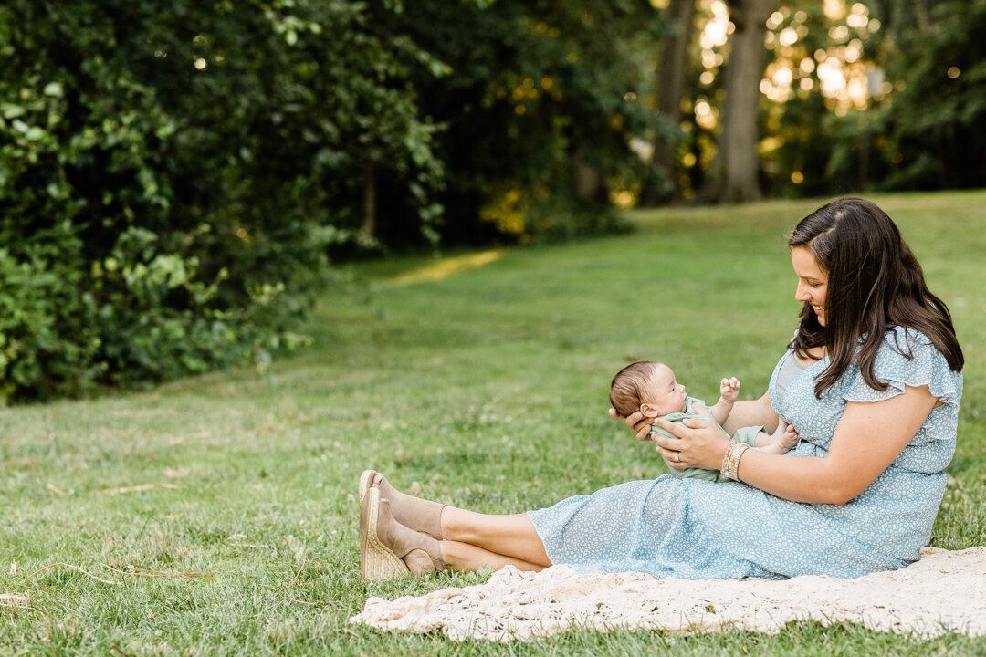 Mother sitting in grass looking at baby boy