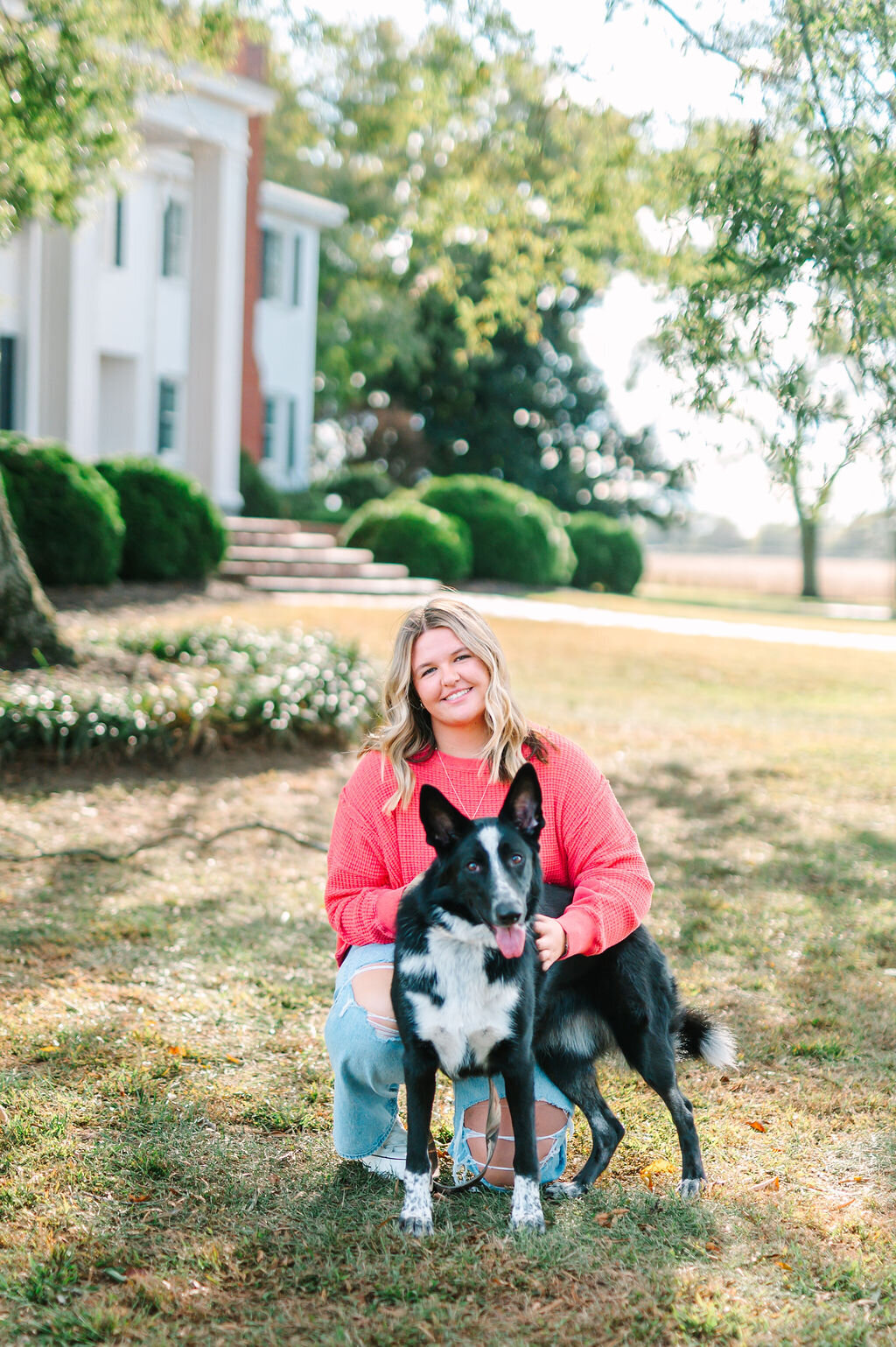 a high school senior posing for a picture with her dog
