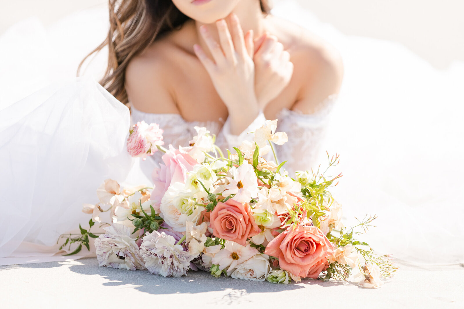 bright light and airy wedding photo of bride  with bouquet of flowers