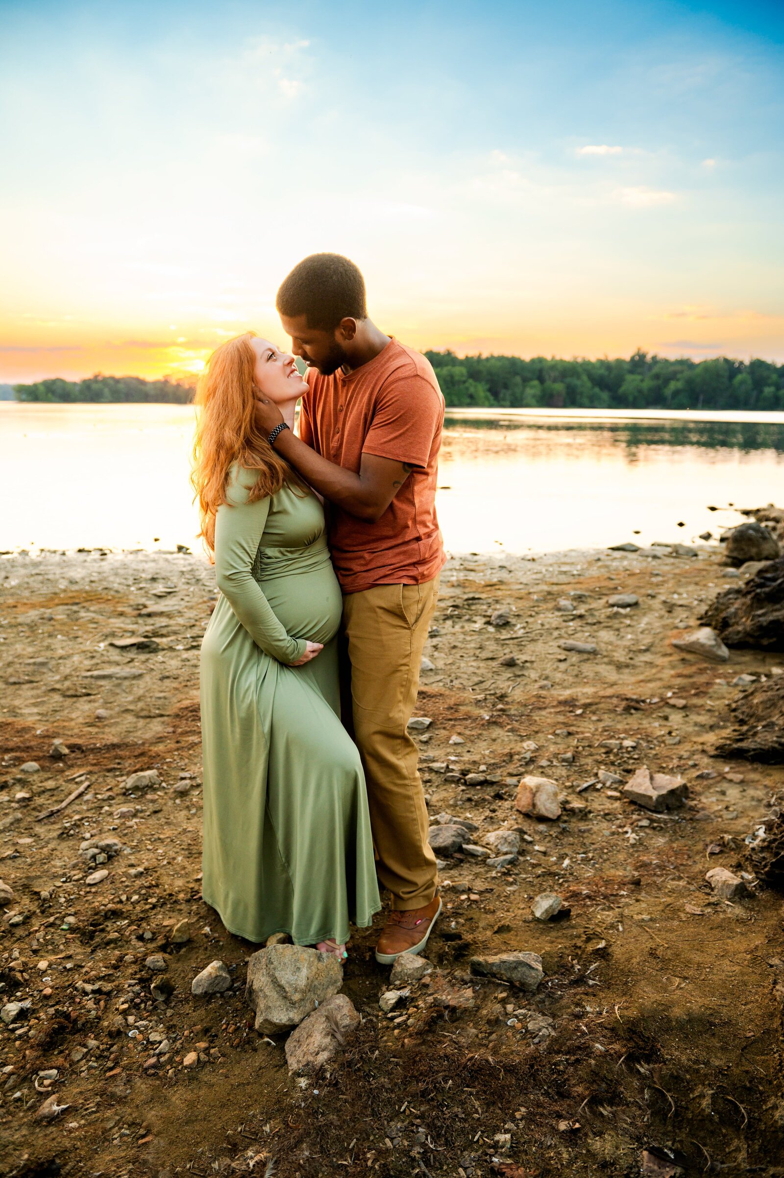 pregnant mom kissing her husband on the beach