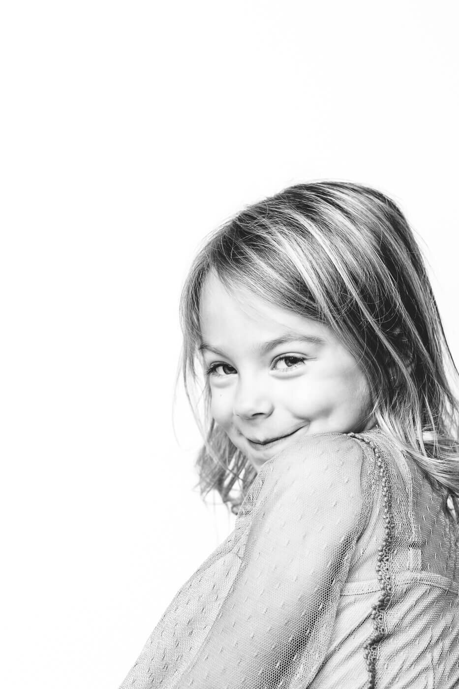 Young girl looking at Tampa photographer with a mischievous grin