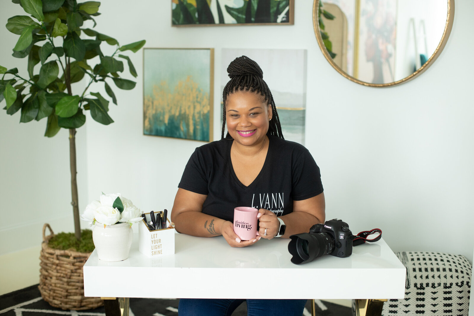 black woman sitting at desk with pink mug
