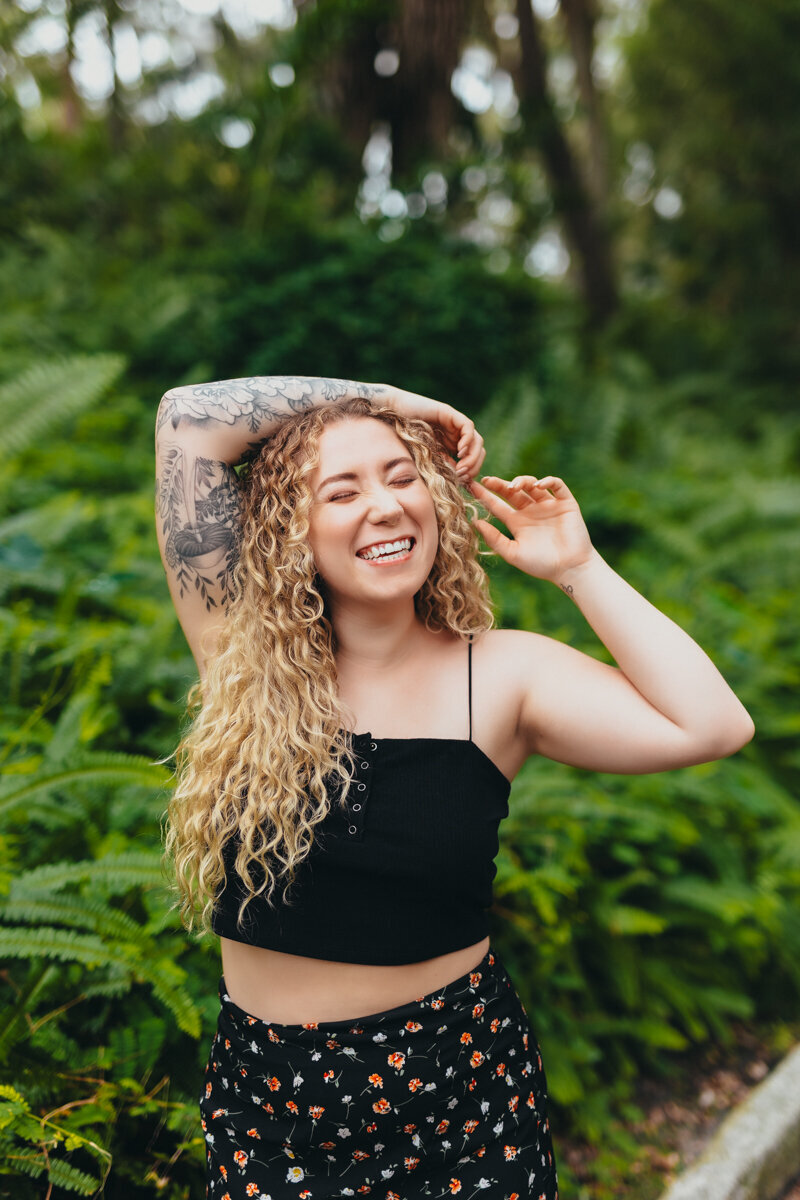 Woman giving a cheesy smile in a green area