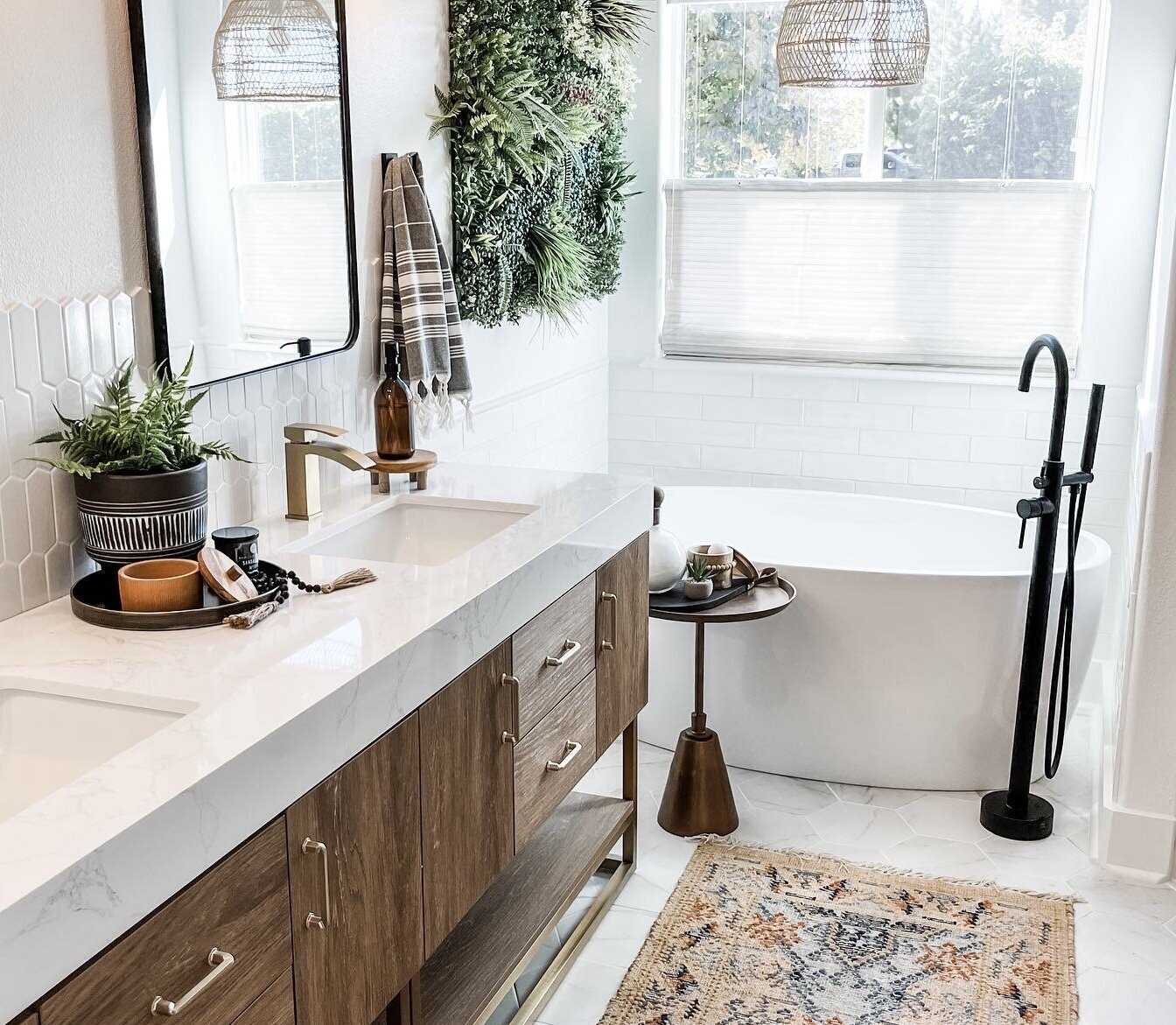 bathroom tub with black faucet wood and marble vanity with gold faucet