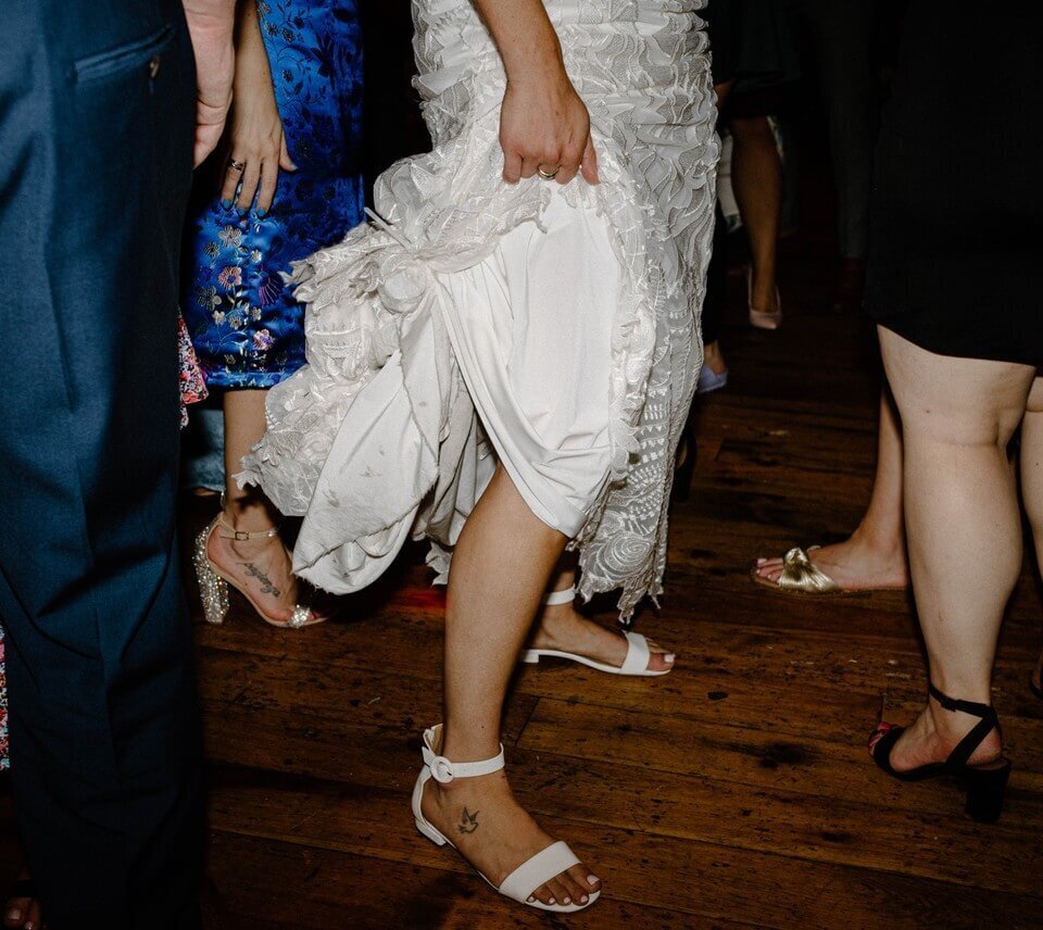 creative and realistic shot of bride at the end of reception holding dress at washington dc winery wedding
