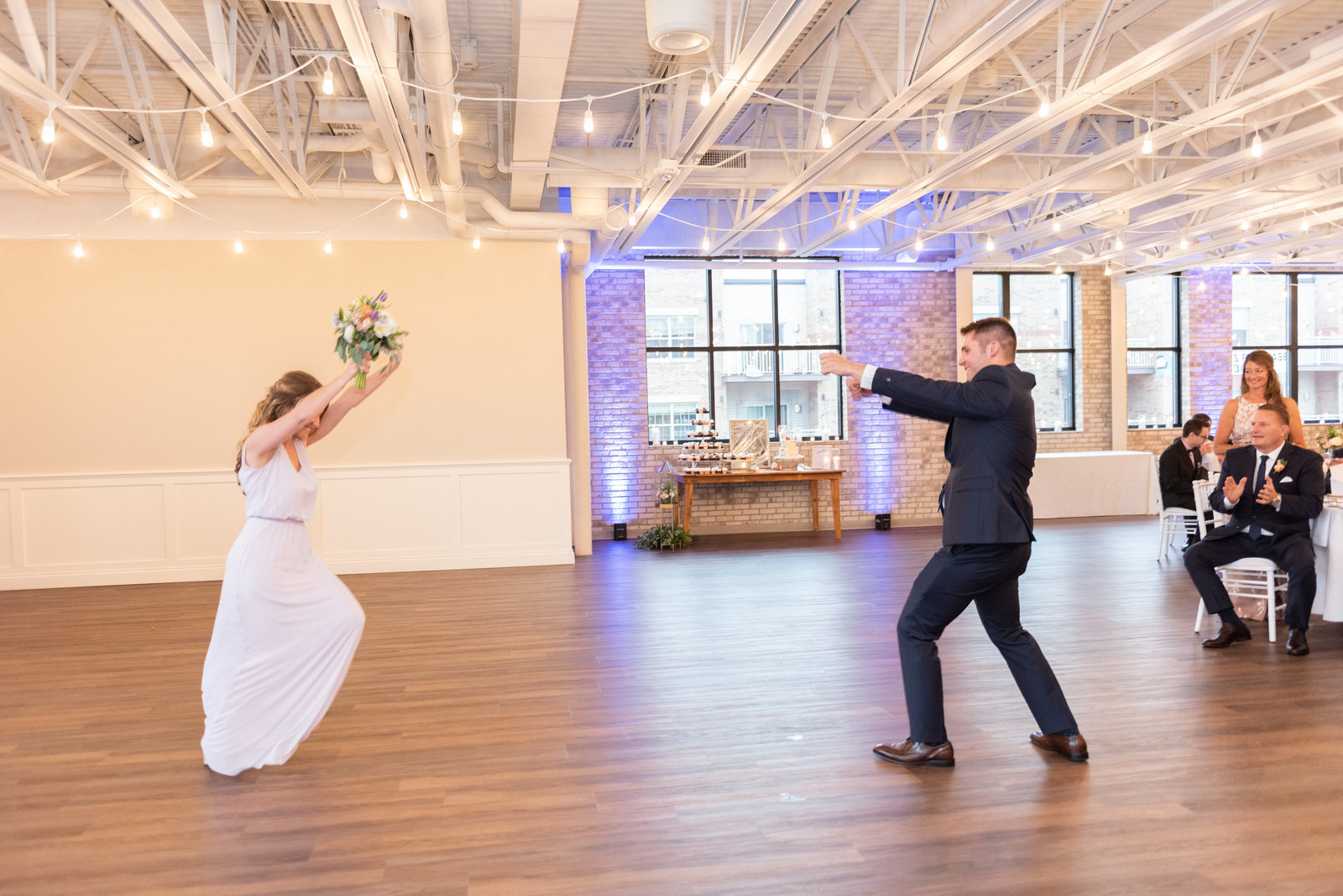 Bride and groom dancing on a wooden dance floor
