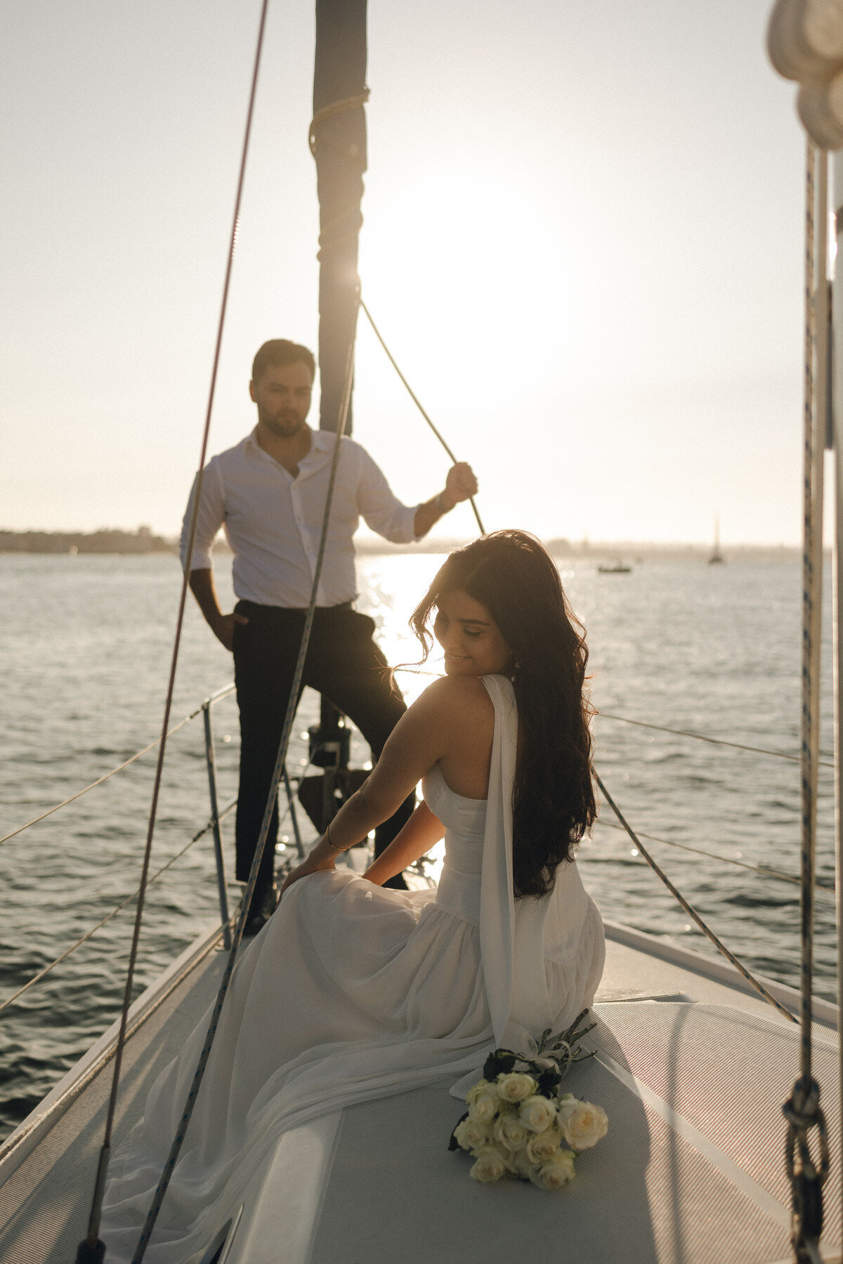 Bride and groom on sailboat at golden hour, romantic destination elopement photography on the West Coast by Tarah Shea