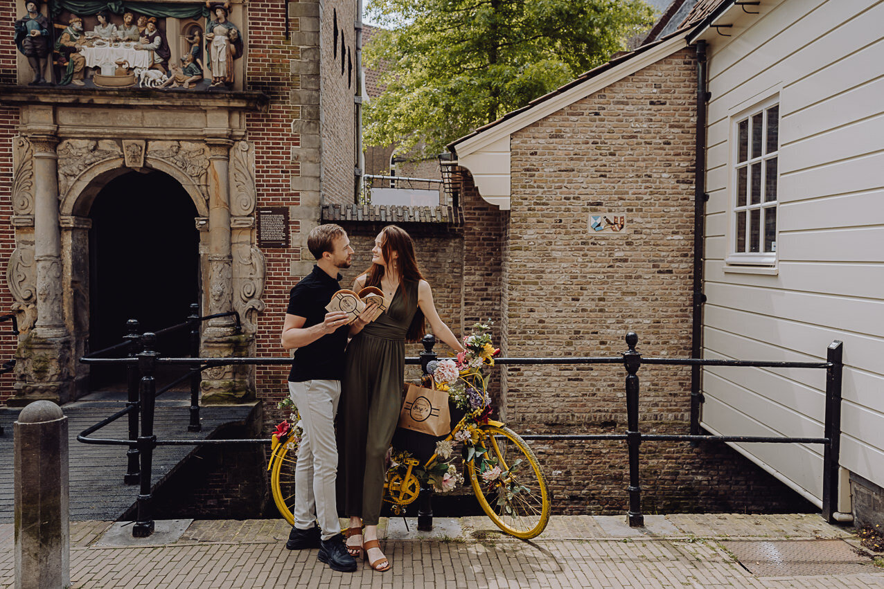 Stel op fiets voor het Museumcafe met een verse siroopwafel van siroopwafelbakkerij van Vliet