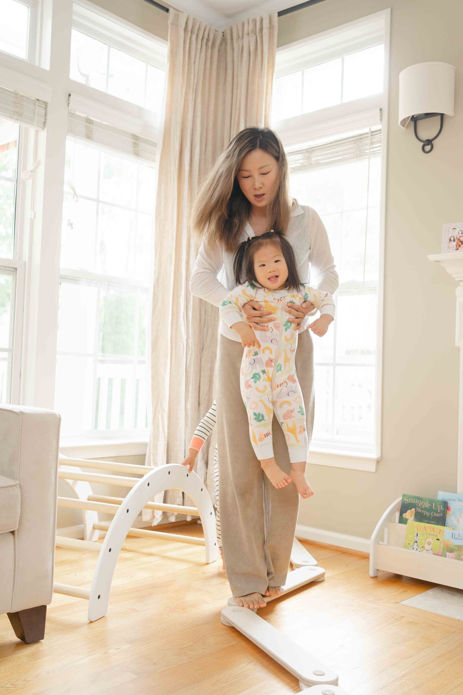 mom and daughter playing on balance beam taken by Vienna,VA product photographer