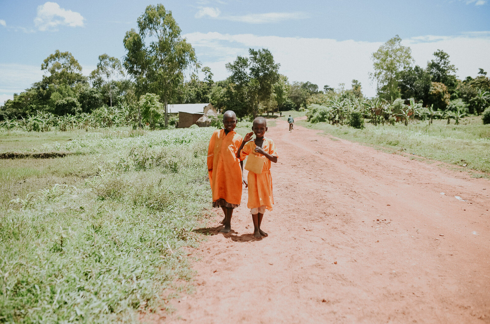 Two young kids on a dirt road .