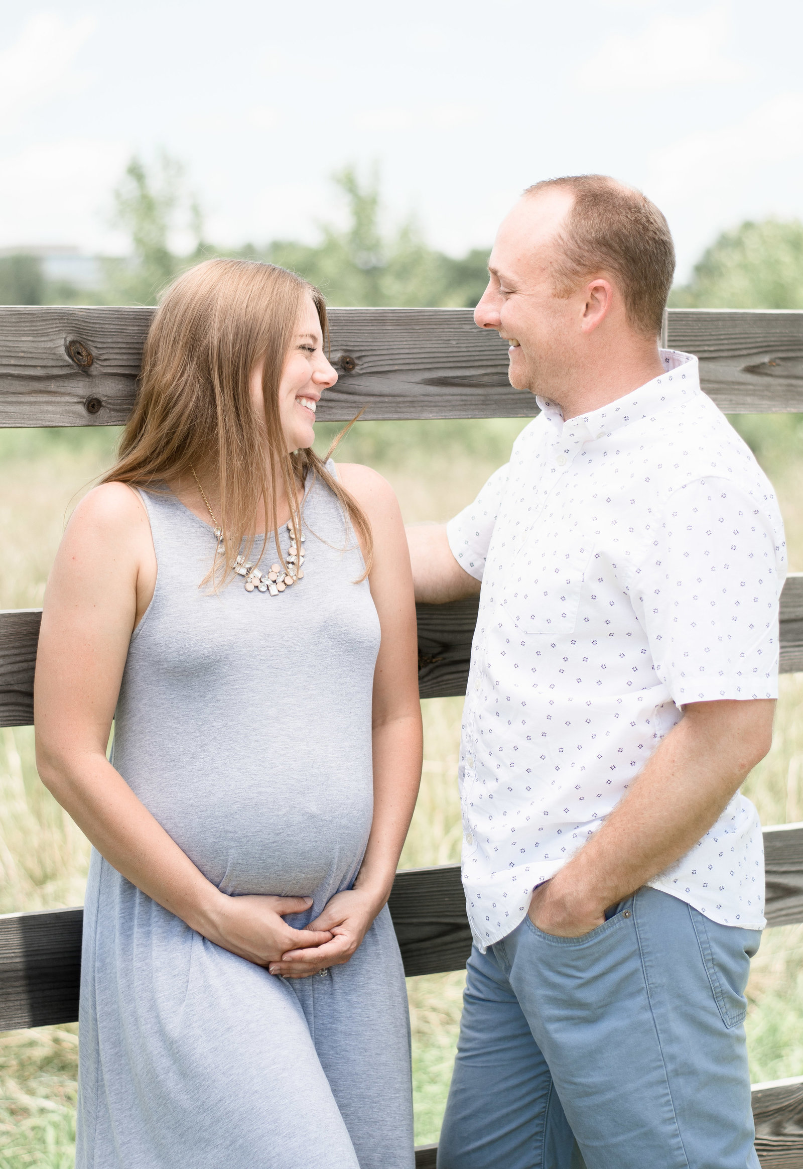 Charlotte Maternity photographer shot of couple along fence line in uptown charlotte