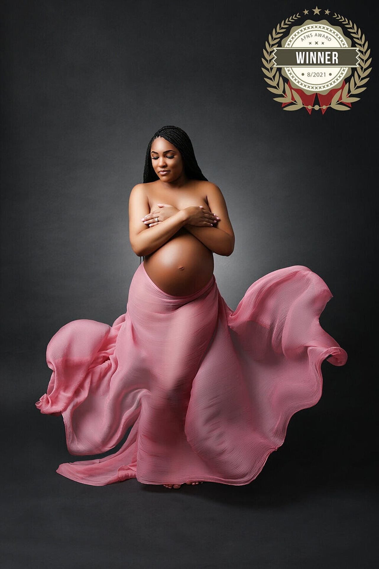 Expectant mother posing gracefully in a professional studio