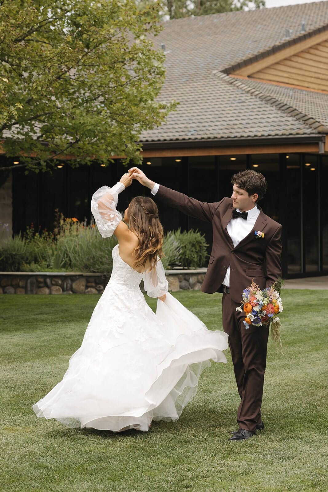 Groom twirling the bride on the lawn at Applegate Christian Fellowship