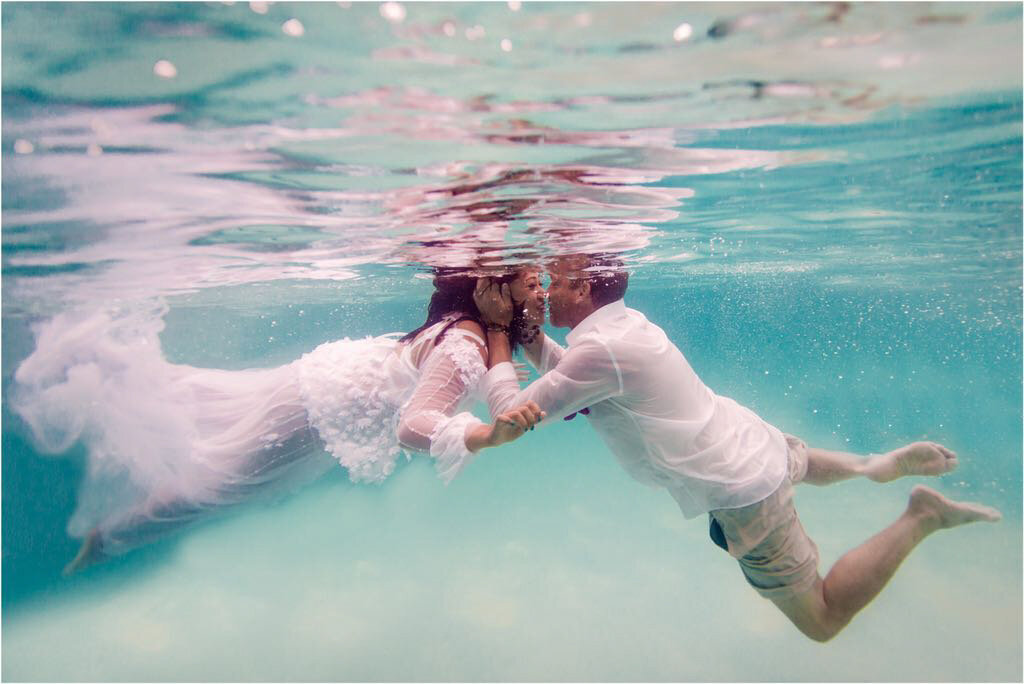 turquoise water and wedding clothes worn by bride and groom underwater