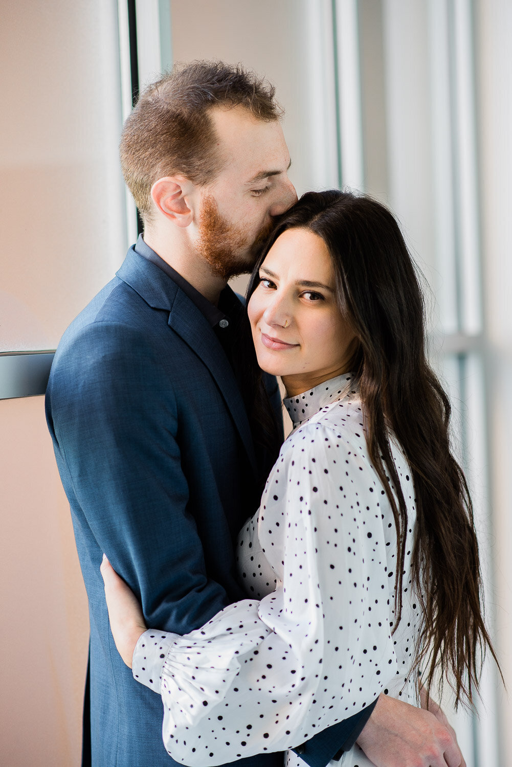 couple face each other kiss on top of head