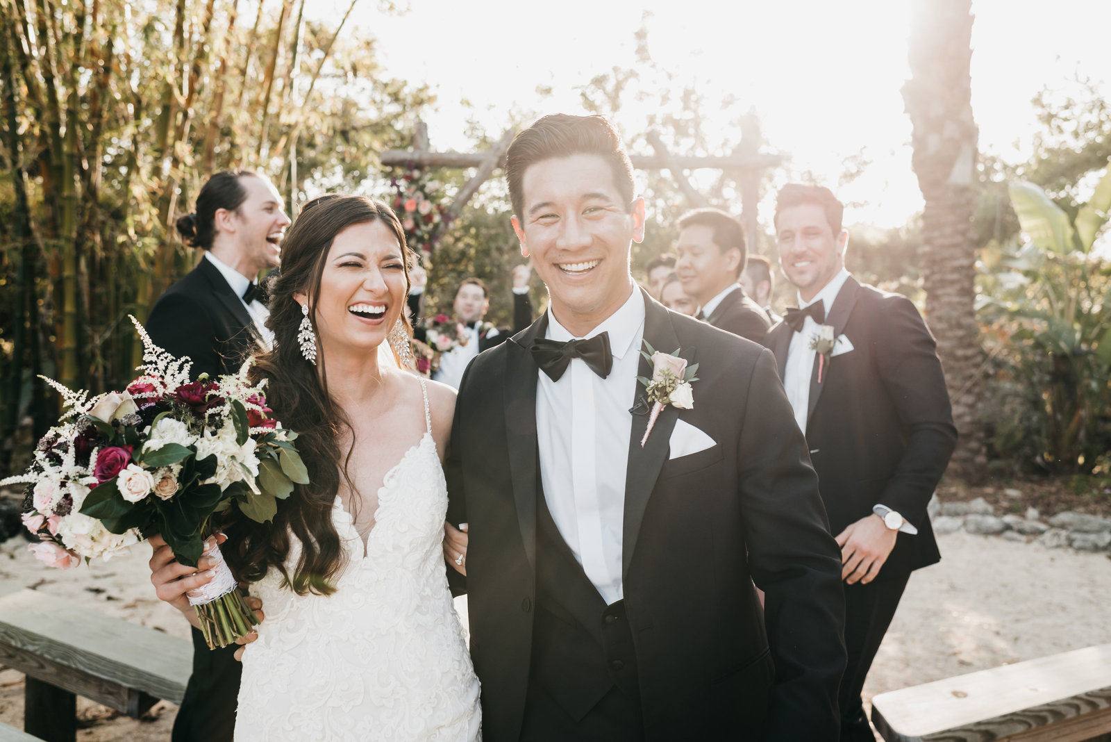 Couple smiling at camera with wedding party