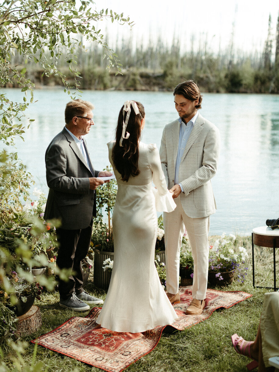 couple holding hands as their officiant performs their ceremony
