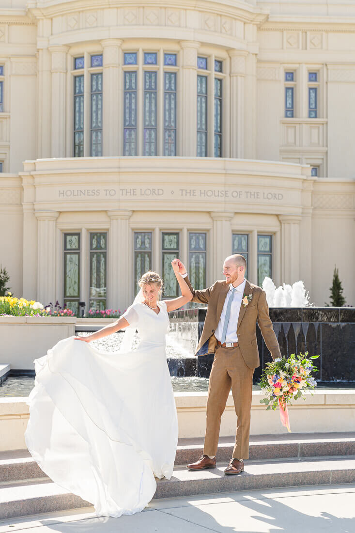Salt Lake photography of a bride and groom dancing in front of the black fountain at the payson temple in the spring
