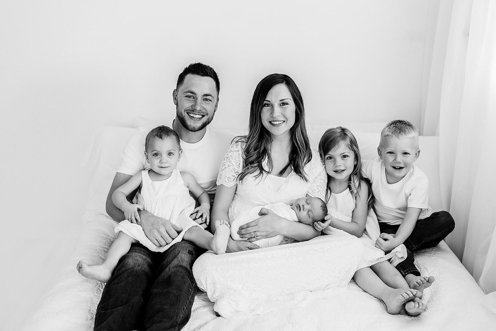 a family poses at home during their newborn photography session in pensacola