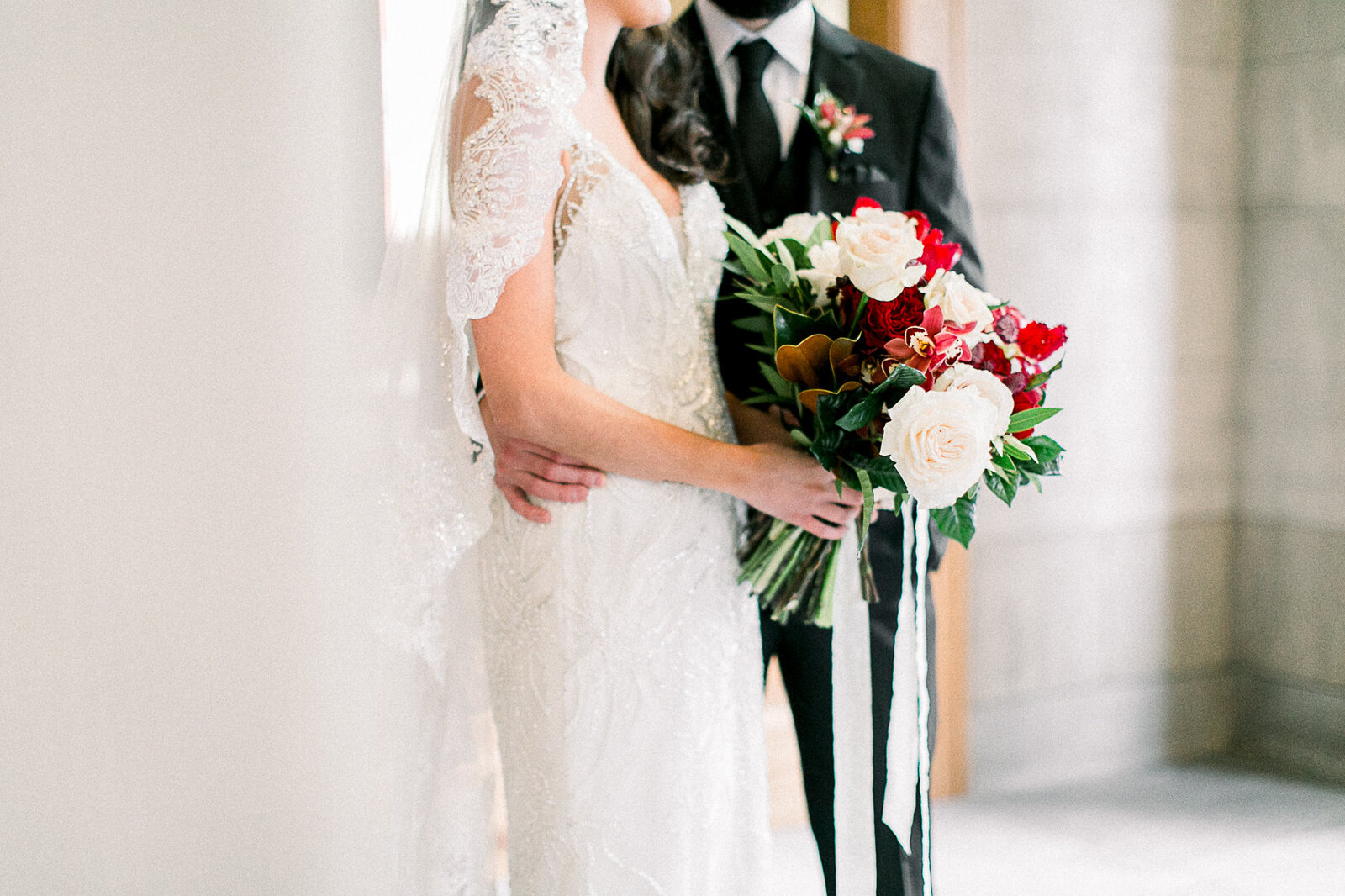 Image of a bride and groom standing side by side highlighting the wedding bouquet