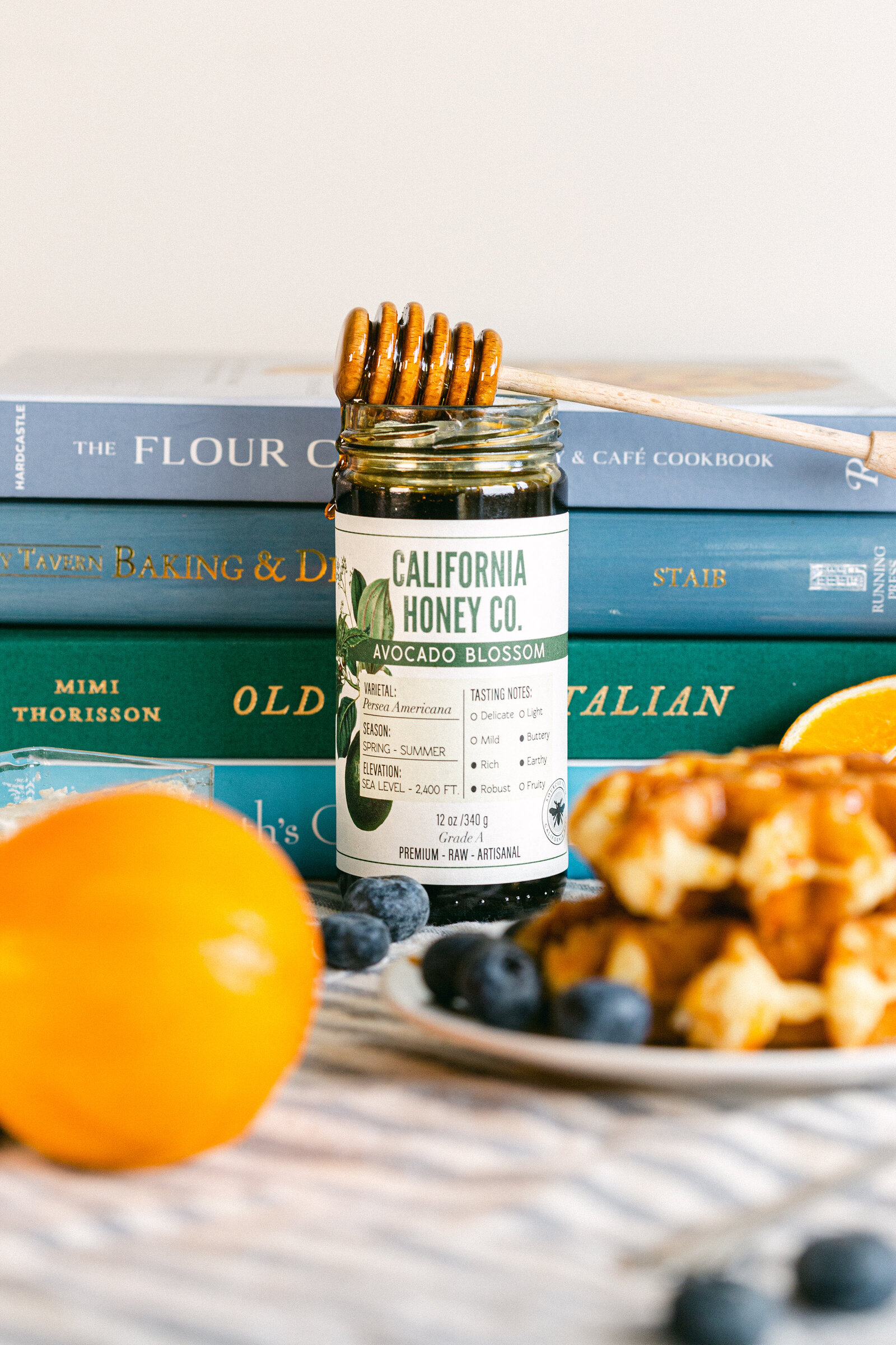Chelsea Loren branding product photographer styled food photography with oranges, cookbooks, waffles for California Honey Co in San Diego