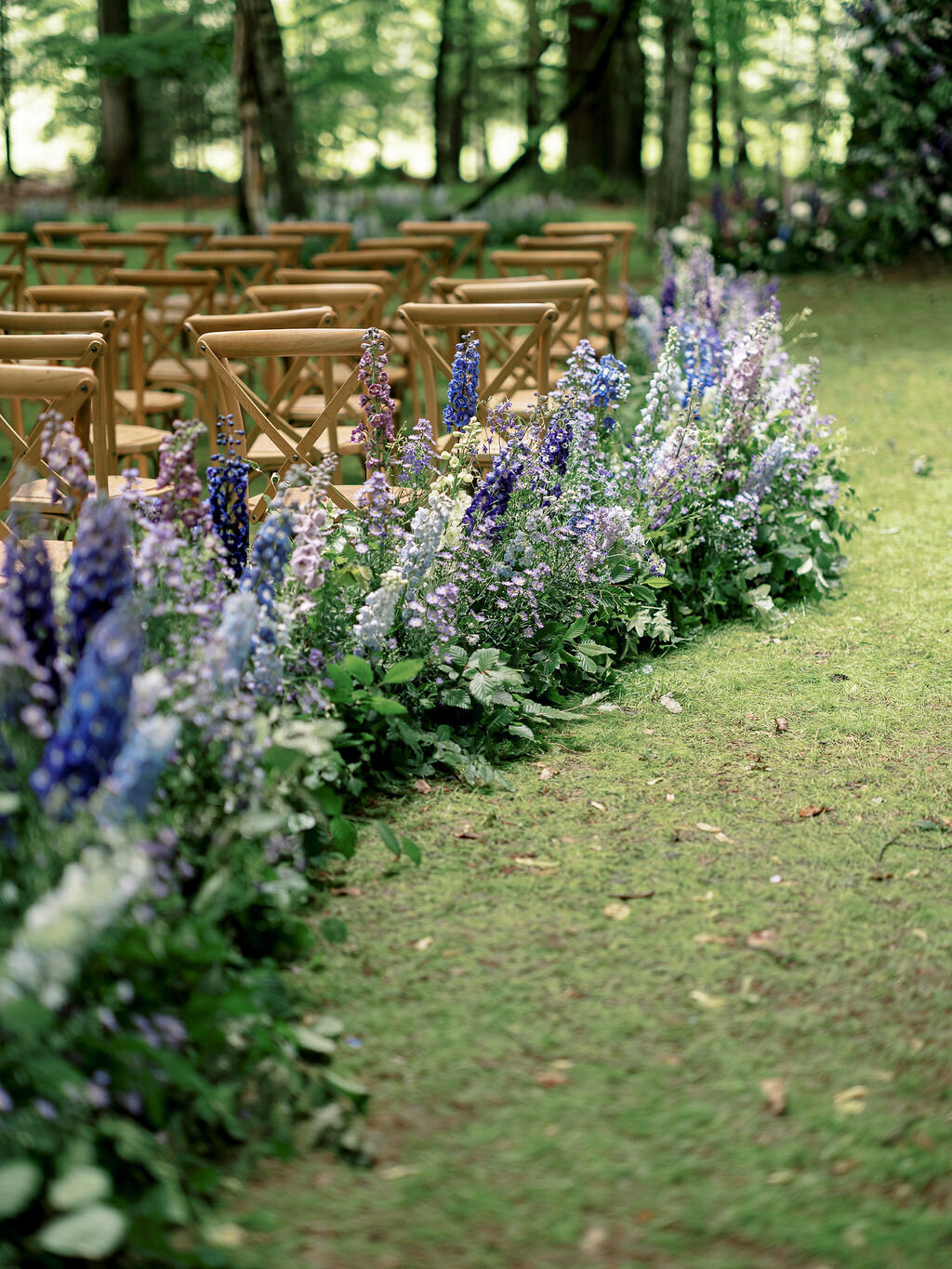 blue floral aisle with delphiniums in the forest