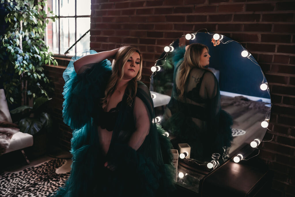 maternity boudoir of woman in green robe sitting in front of vanity