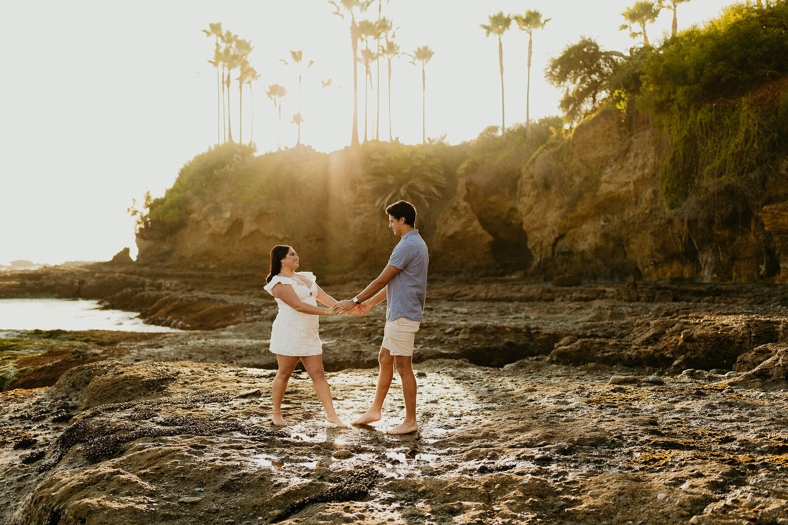 A couple holding hands during their engagement photo session in Laguna Beach, California