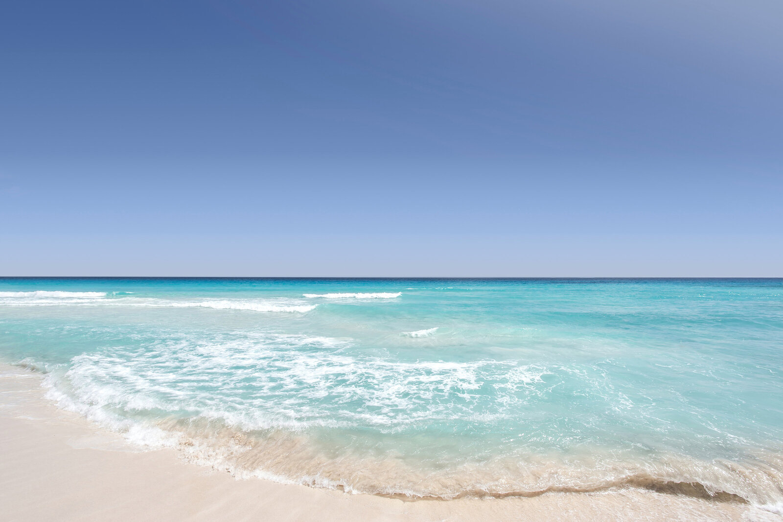 Beach scene with blue sky, ocean and sand