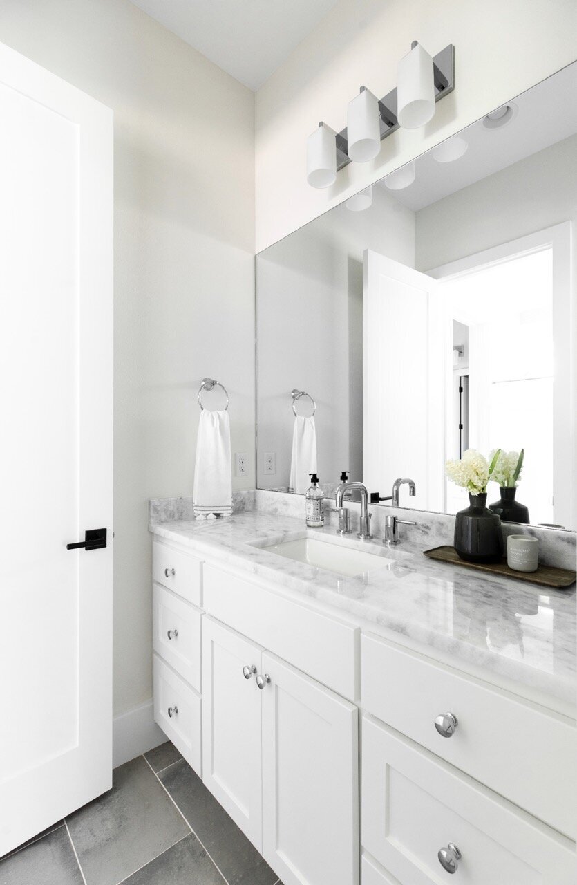 Nuela Designs White cabinets marble counter bathroom