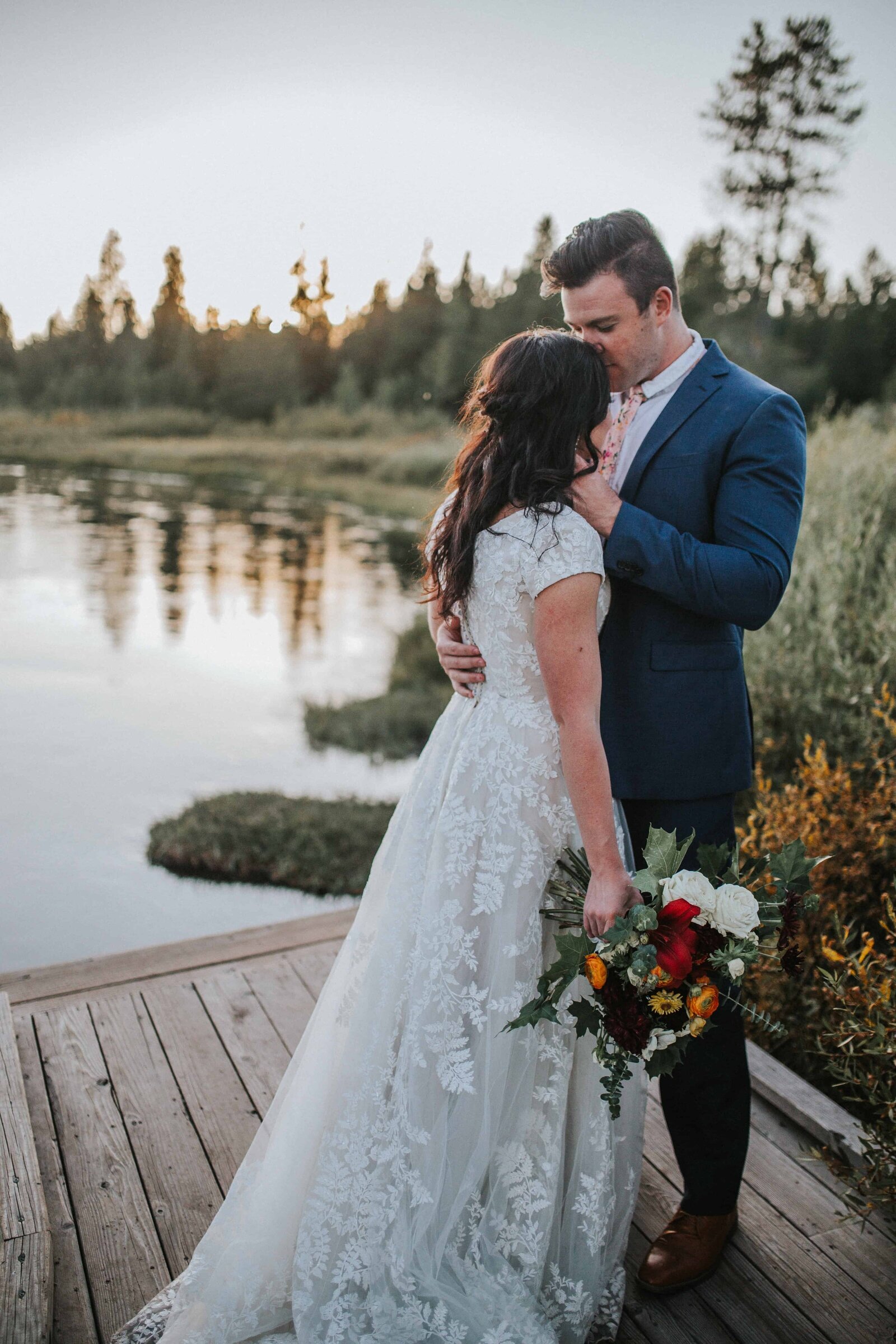 Lake Tahoe wedding photographer captures  groom kissing bride's forehead  during sunset portraits