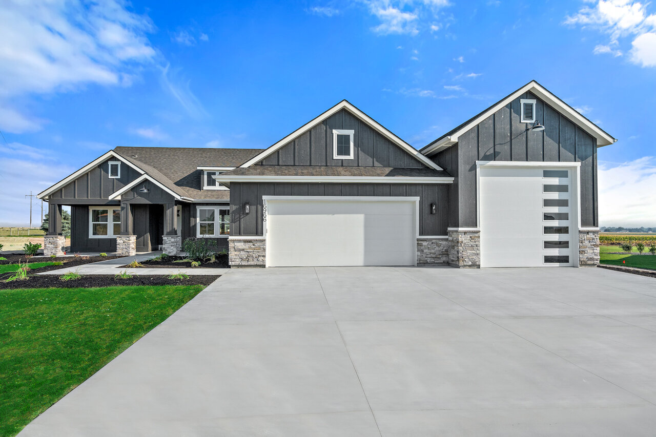 new home on quiet street gray house with white garage doors