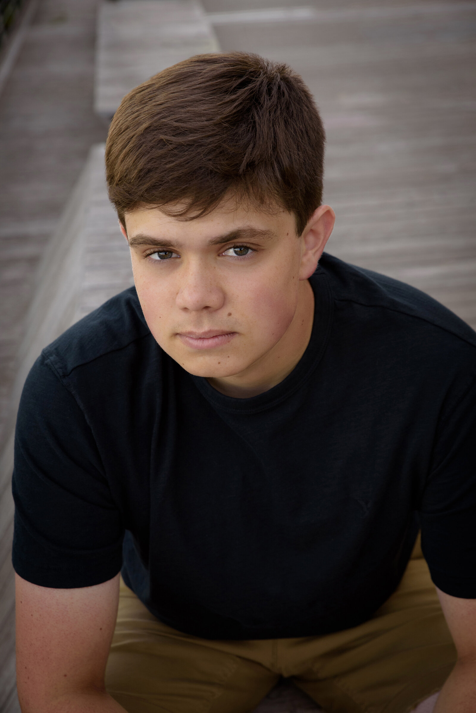 headshot of High school senior boy sitting on city deck in Green Bay, Wisconsin