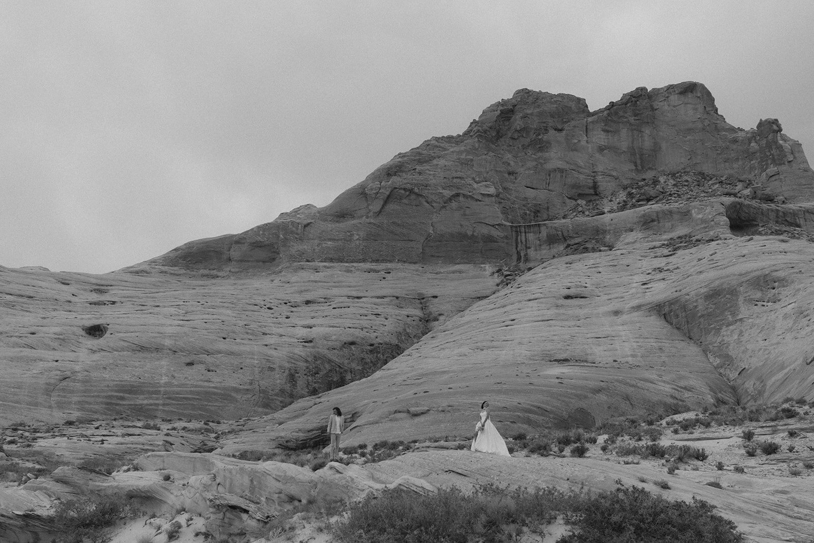 bride and groom walking through canyon in the desert