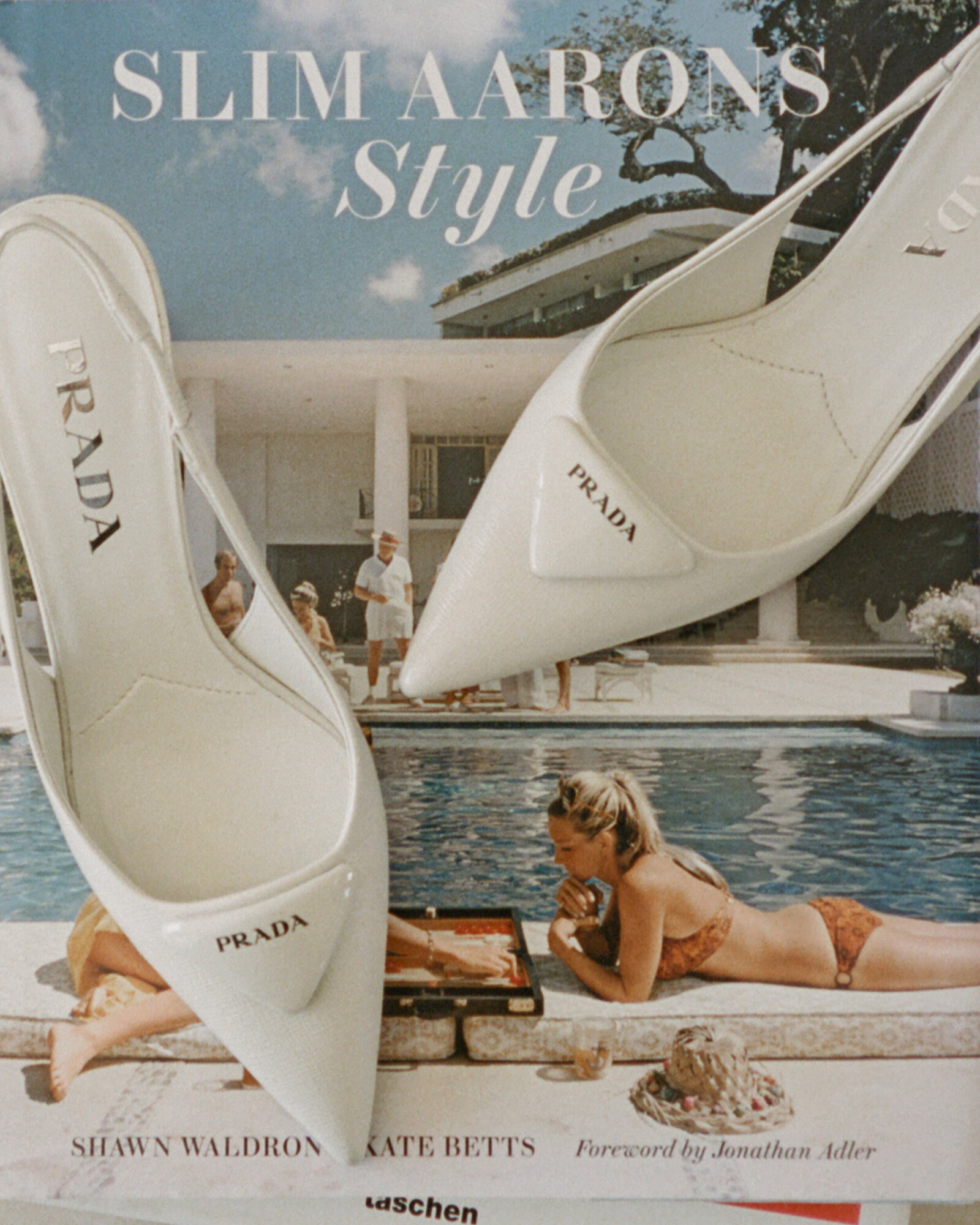 White pointed toe Prada bridal heels laying on top of Slim Aarons coffee table book 