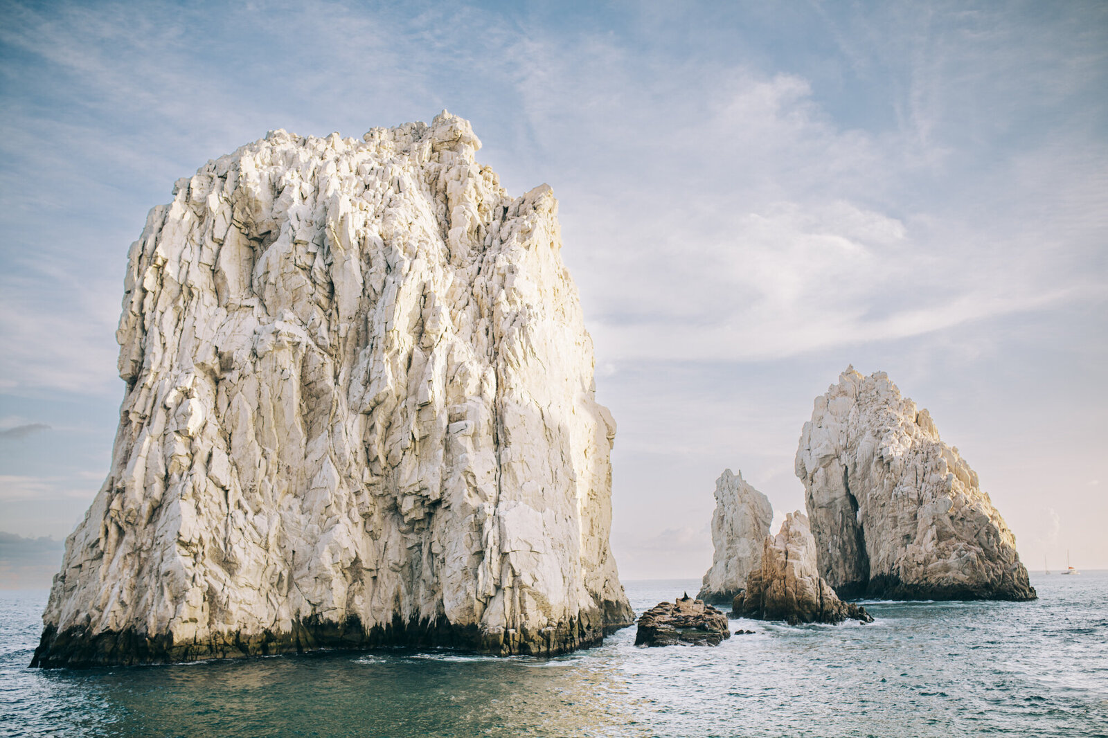 Rugged white cliffs rising from the sea under a soft sky, a dream location for any destination wedding photographer.