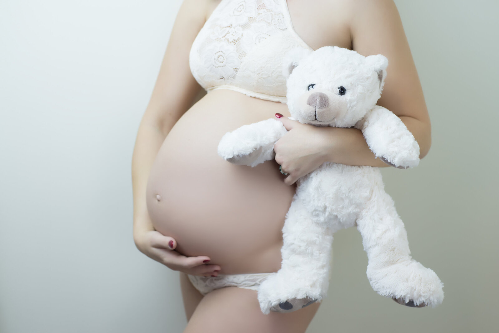 Pregnant woman maternity photo with belly and teddy bear