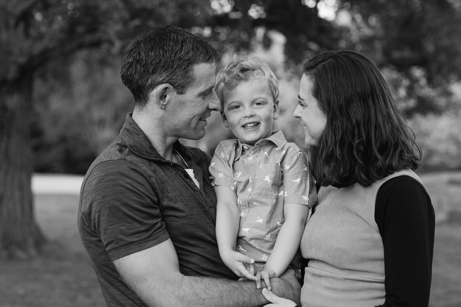 mom and dad looking at son in park