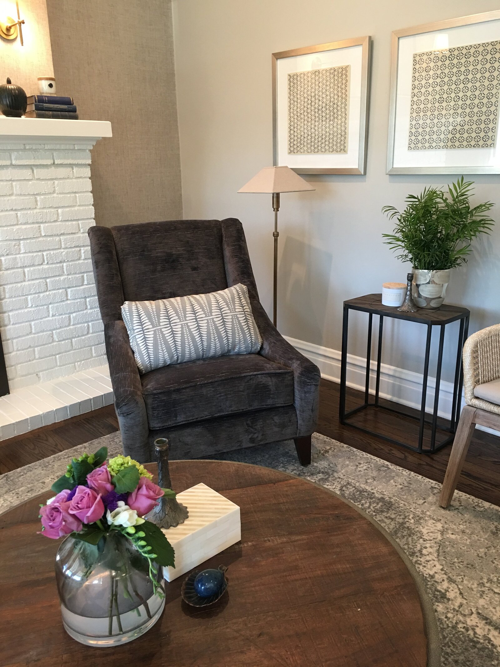 Dark grey velvet chair and white brick fireplace