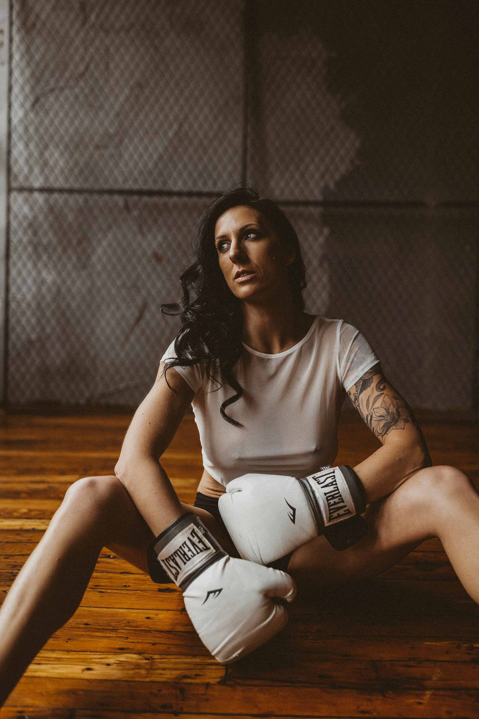 woman sitting with a boxing gloves on