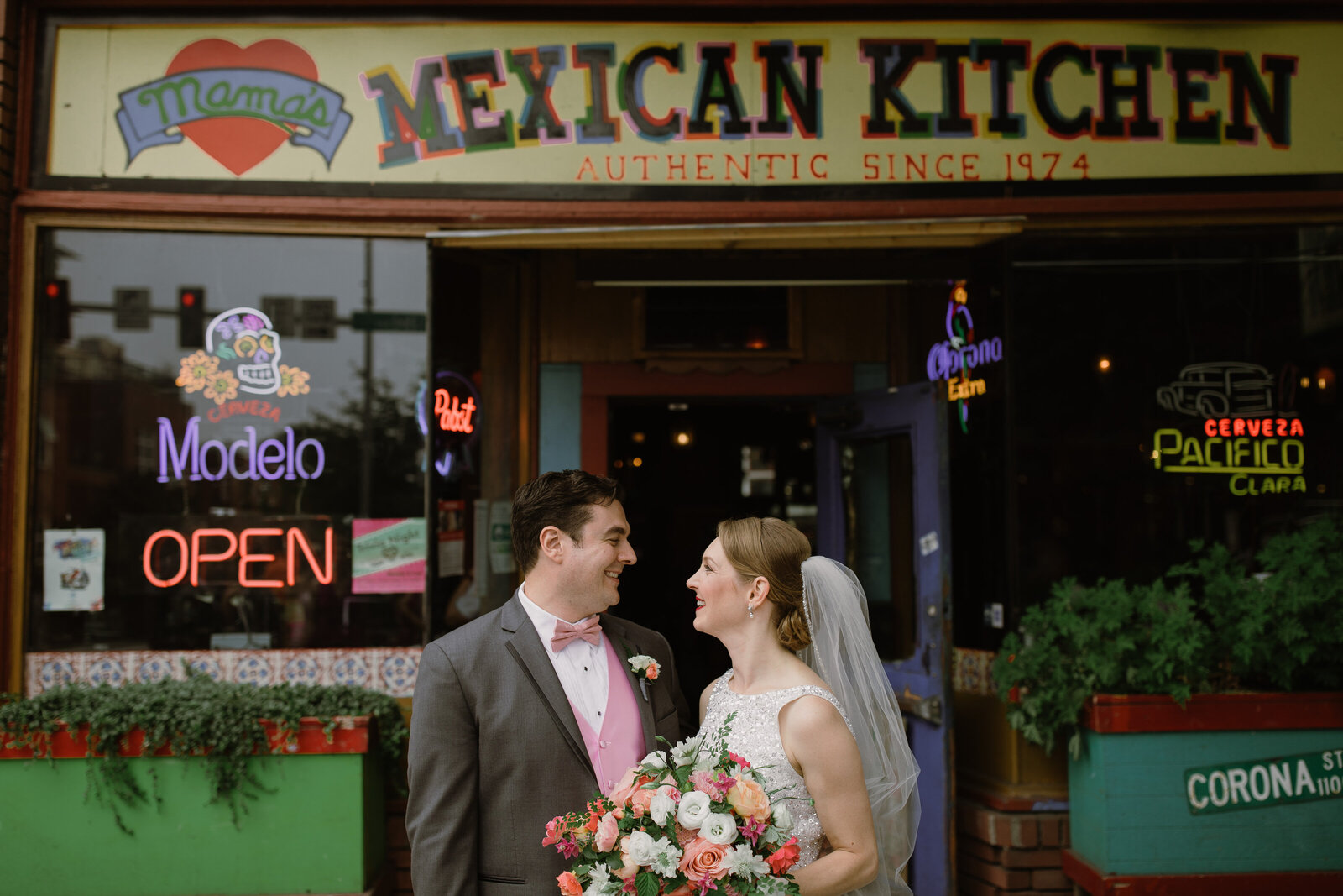 bride and groom standing on a street in Downtown Seattle with Mamma's Mexican Kitchen in the background.