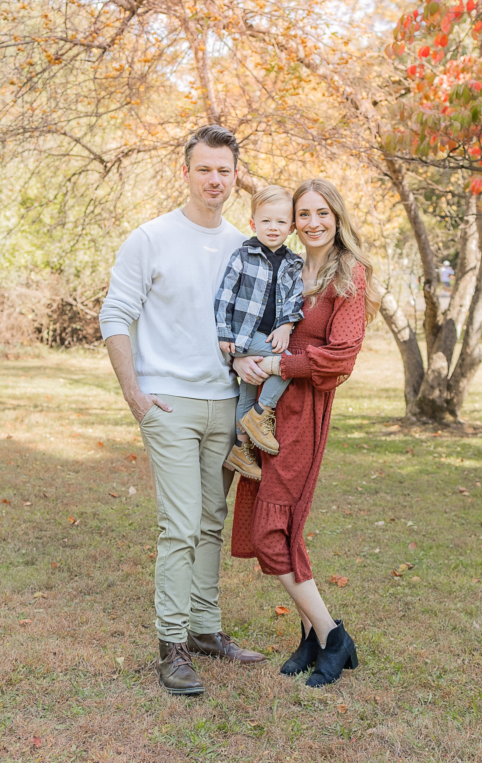 Family of three posing during a fall family session in Bergen County, New Jersey