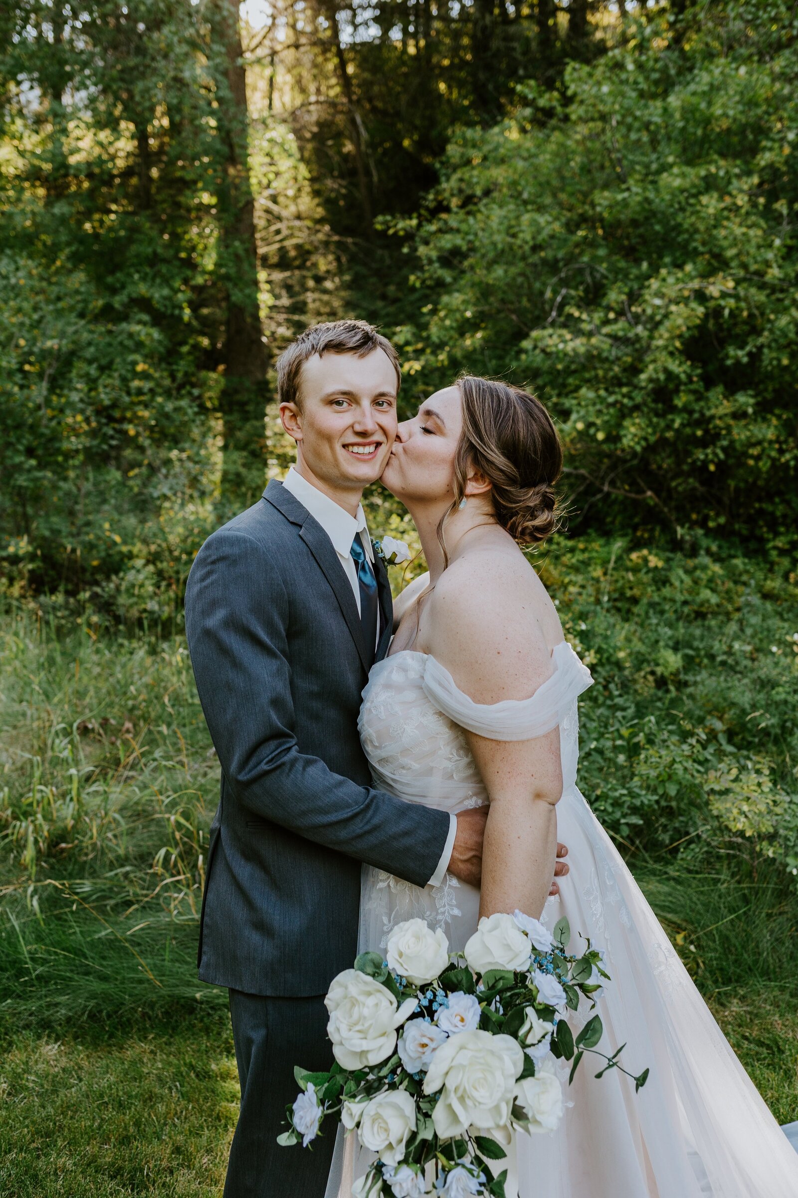 Bride kisses the groom at their woodlands wedding.