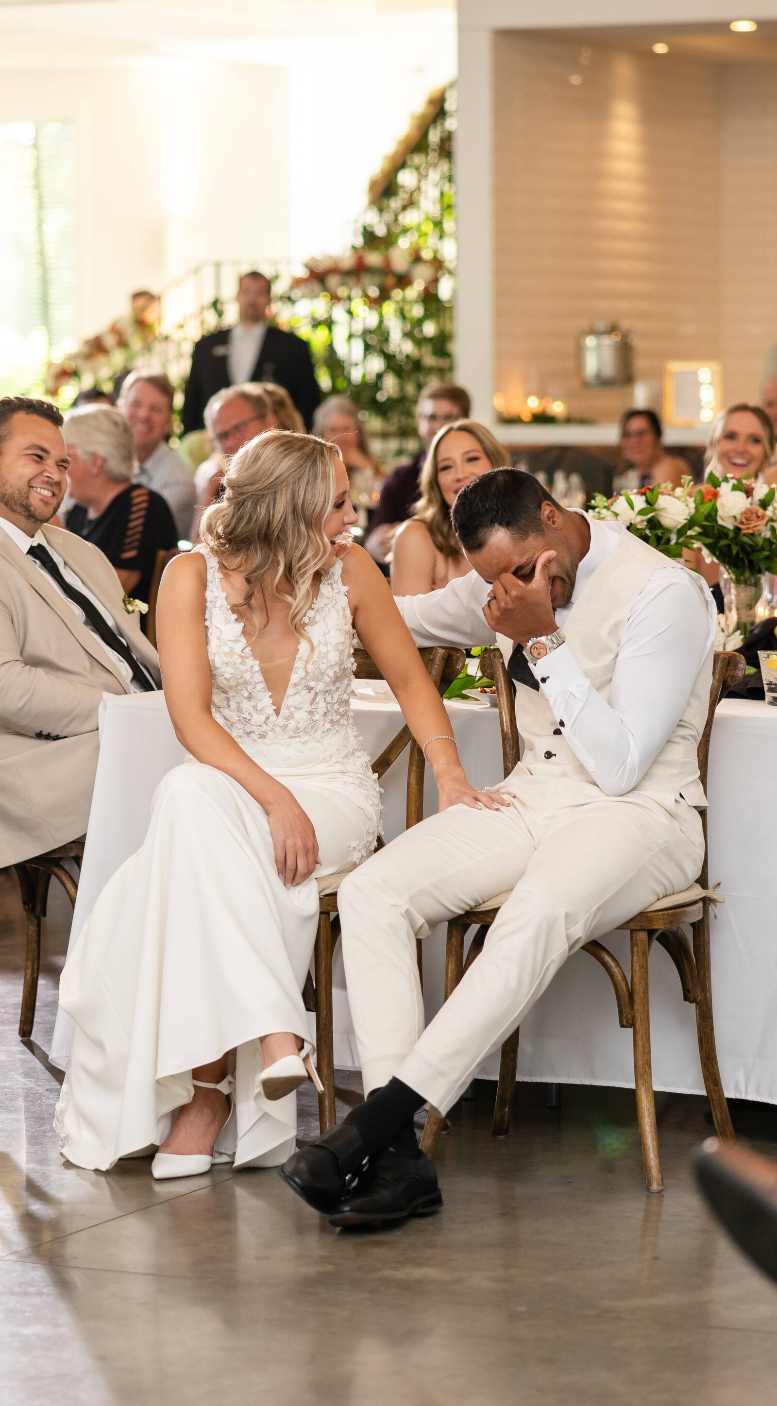 Bride and groom laughing and crying during wedding reception speeches