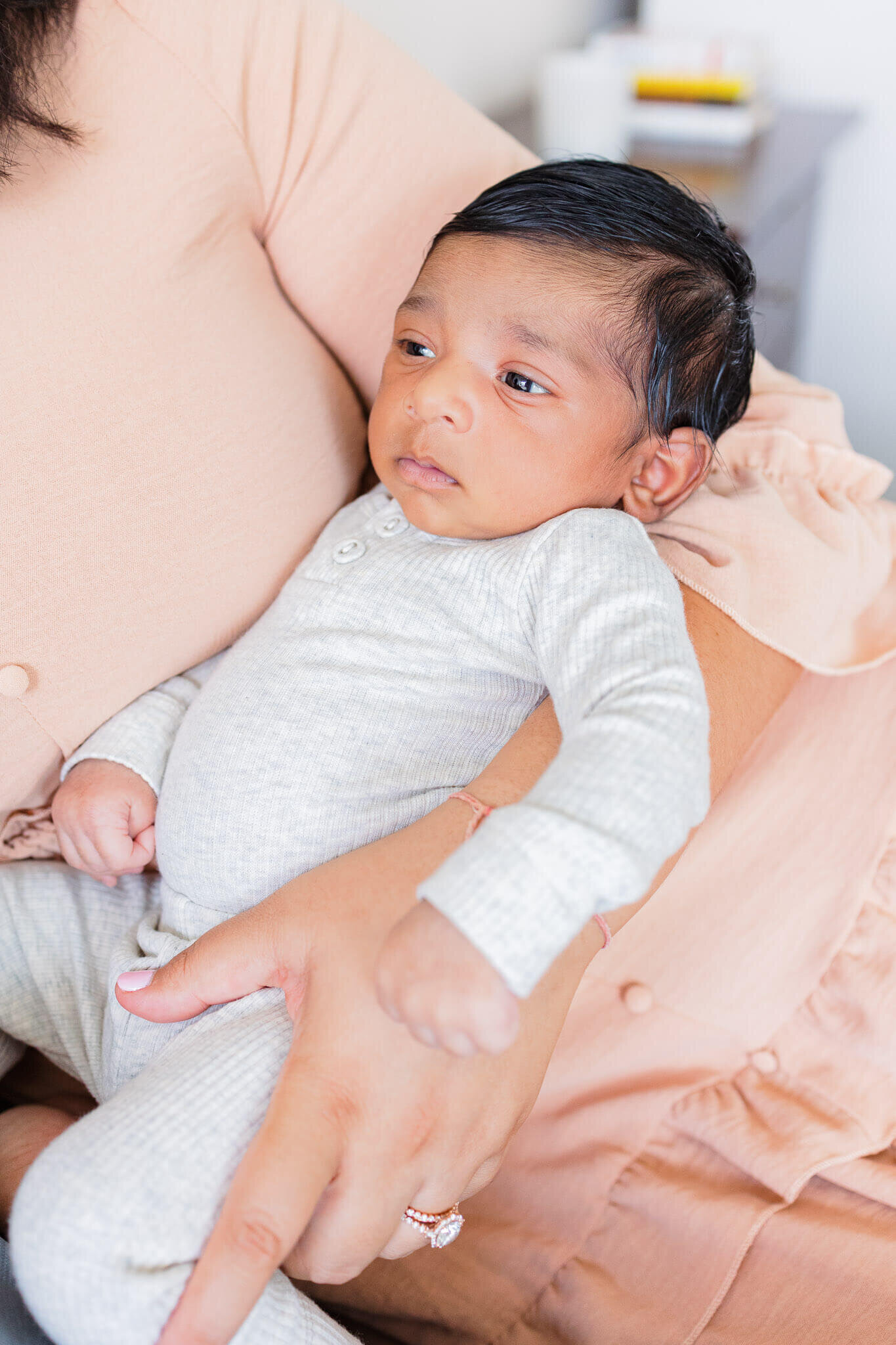 A close-up of a newborn boy being held in his mom's arms.
