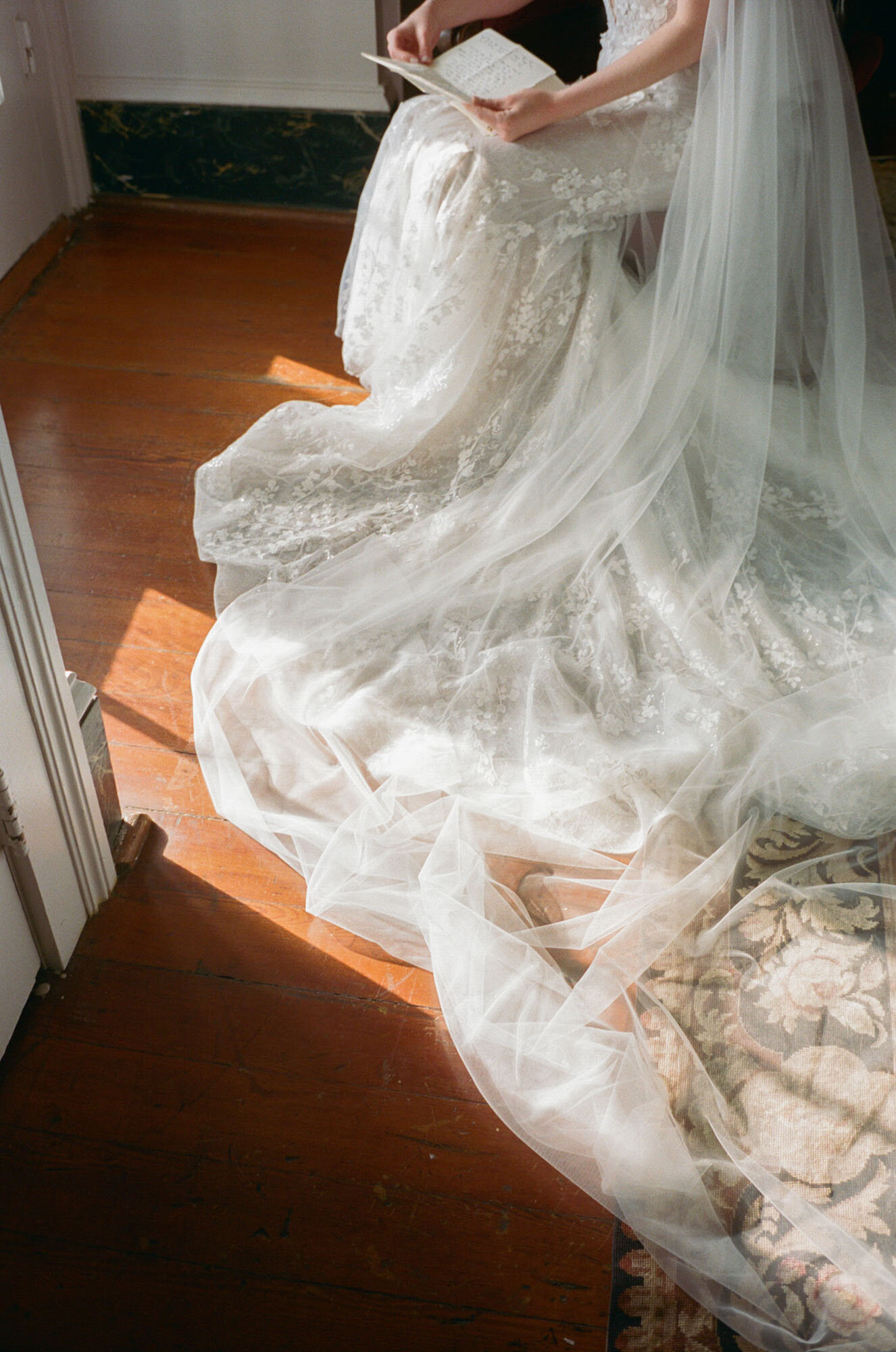 bride reading letter with bridal dress flowing