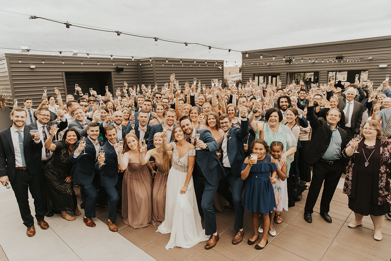 Panoramic shot of a wedding with all the guests toasting